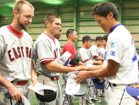 baseball players from CSUEB and FIT exchanging baseball hats.